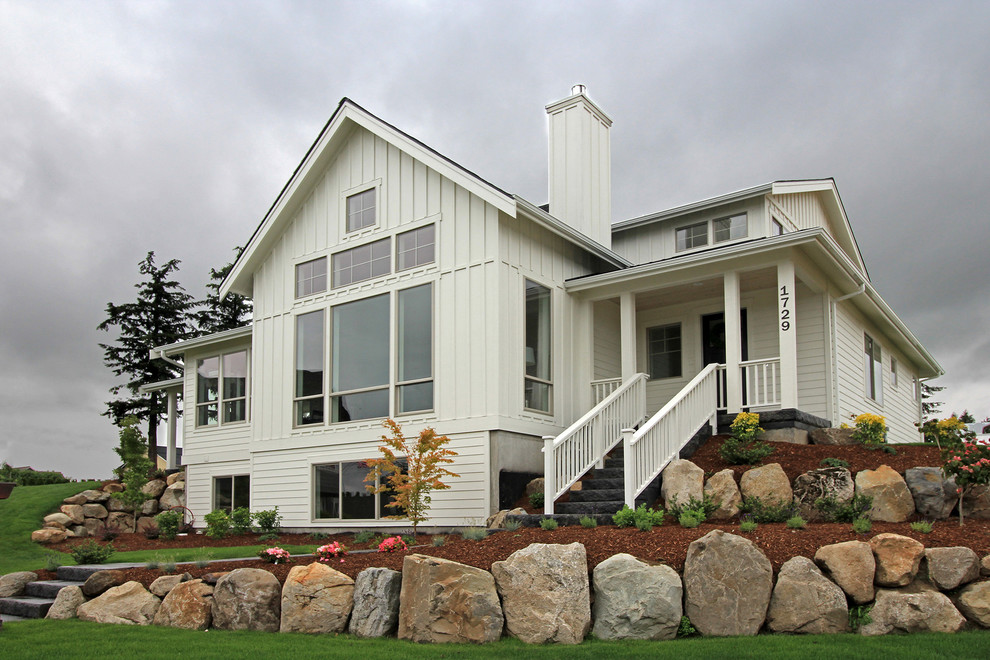 Cette photo montre une grande façade de maison blanche nature en panneau de béton fibré à deux étages et plus avec un toit à deux pans.