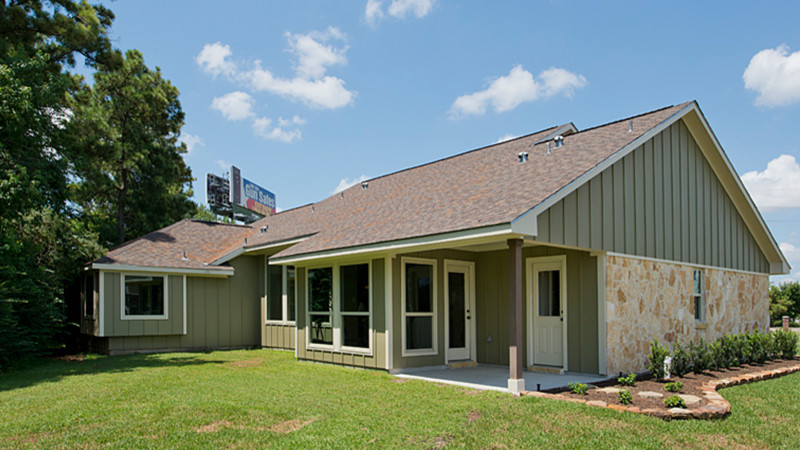 Modelo de fachada de casa verde rural de tamaño medio de una planta con revestimientos combinados, tejado a dos aguas y tejado de teja de madera