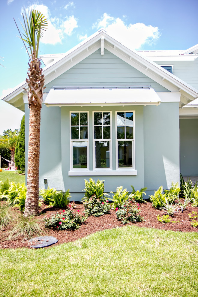 Immagine della facciata di una casa blu stile marinaro a due piani di medie dimensioni con rivestimento in stucco e tetto a capanna