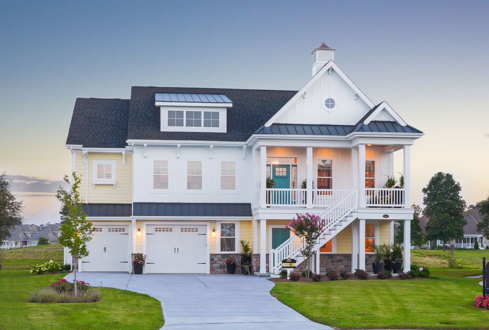 Cette photo montre une façade de maison blanche chic en bois à deux étages et plus avec un toit à deux pans.
