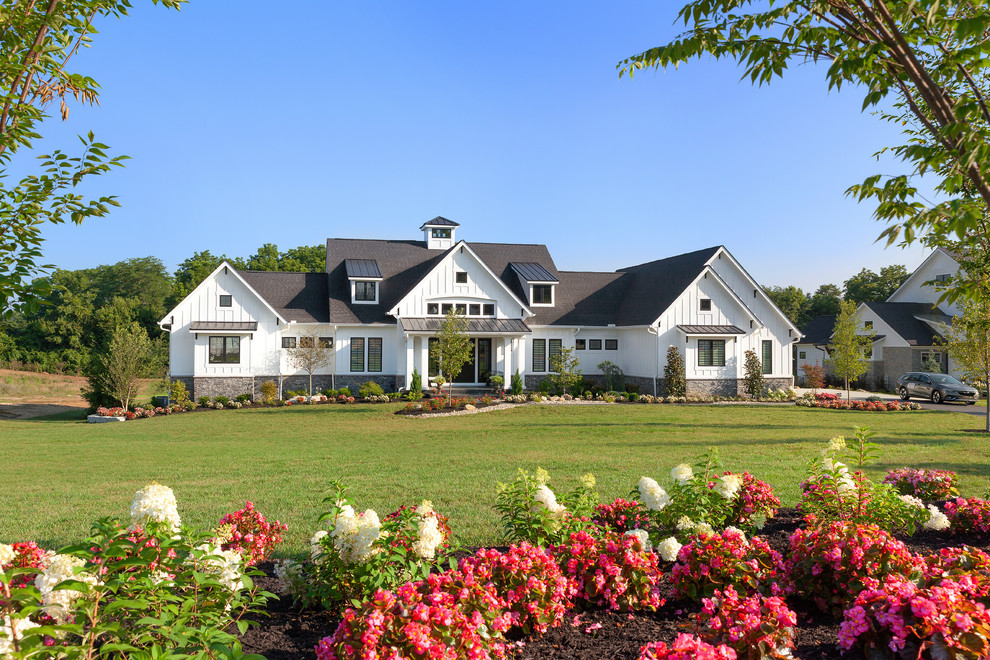 Exemple d'une très grande façade de maison blanche nature en panneau de béton fibré de plain-pied avec un toit en shingle.