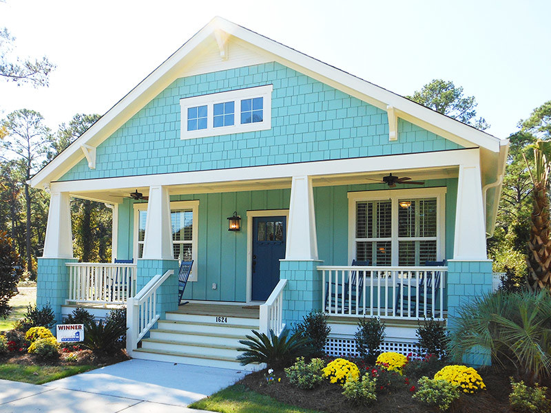 This is an example of a small and blue coastal two floor house exterior in Wilmington with wood cladding and a pitched roof.
