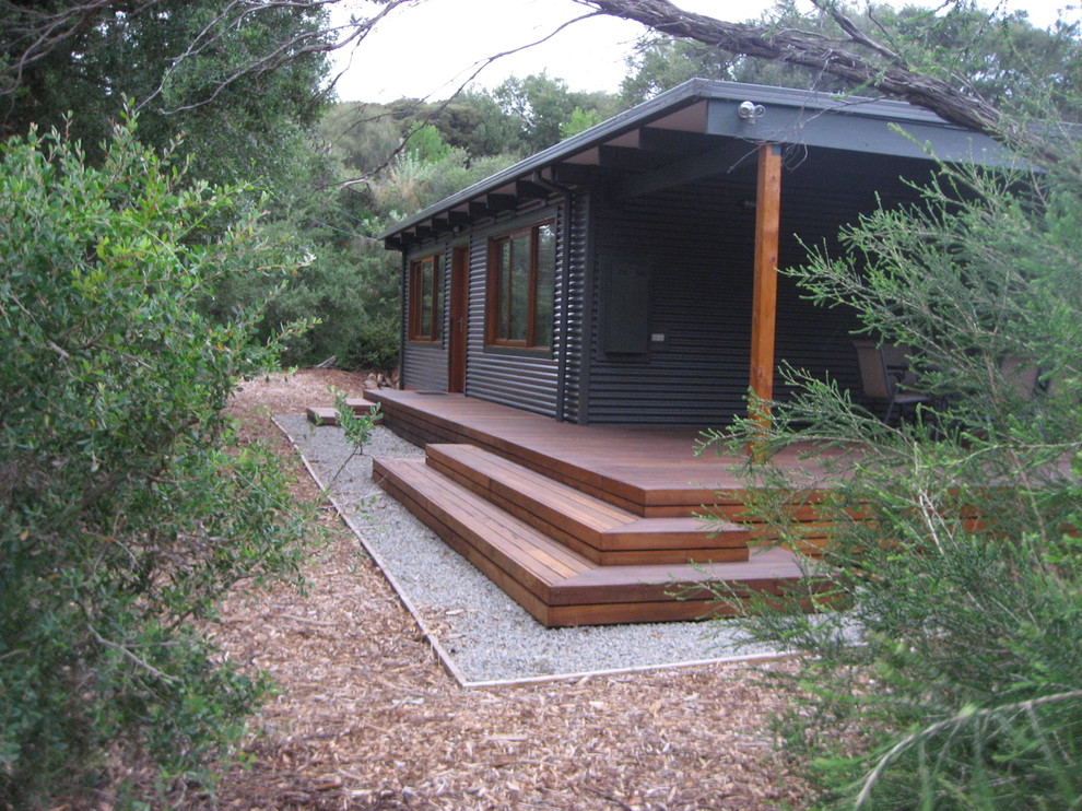 Esempio della villa piccola grigia contemporanea a un piano con rivestimento in metallo, tetto a capanna e copertura in metallo o lamiera
