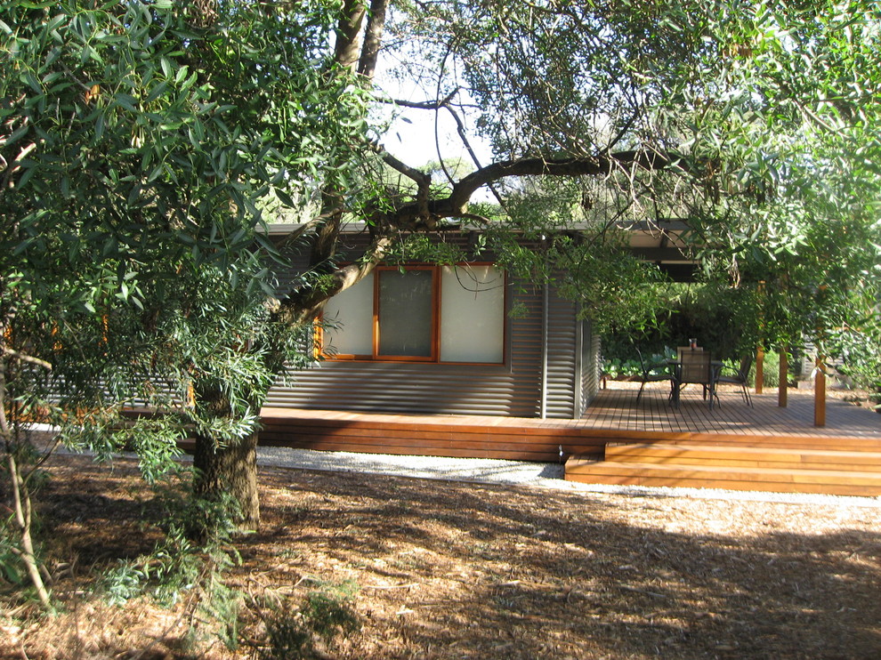 Cette photo montre une petite façade de maison métallique et grise tendance de plain-pied avec un toit à deux pans et un toit en métal.