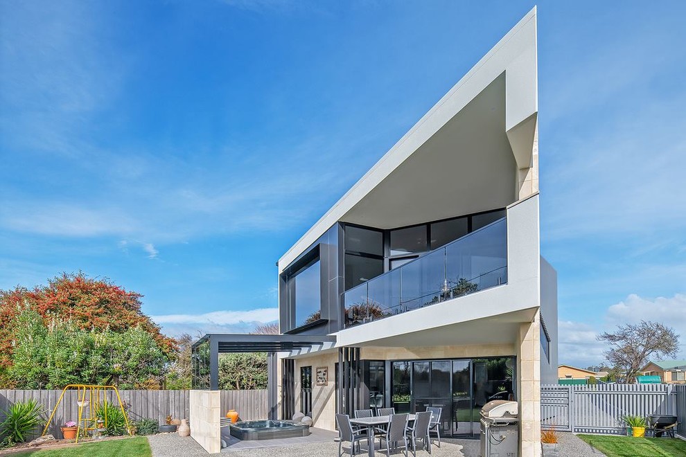 Mittelgroßes, Zweistöckiges Modernes Einfamilienhaus mit Faserzement-Fassade, weißer Fassadenfarbe, Flachdach und Blechdach in Sonstige