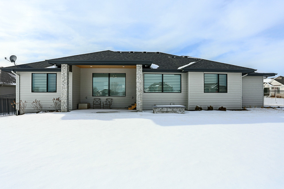 This is an example of a modern bungalow detached house in Omaha with mixed cladding, a hip roof and a shingle roof.