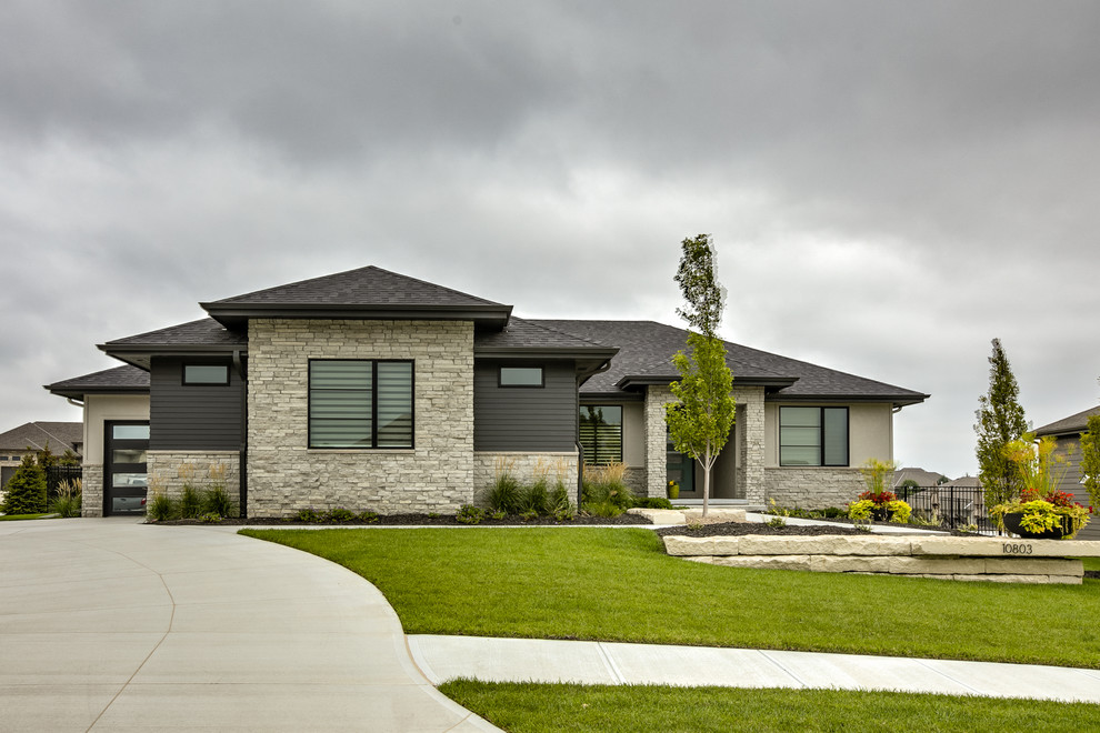 Cette image montre une façade de maison minimaliste de plain-pied avec un revêtement mixte, un toit à quatre pans et un toit en shingle.