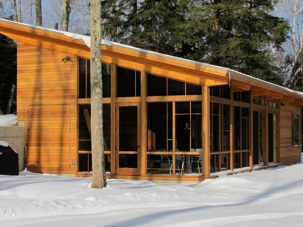 Diseño de fachada contemporánea con revestimiento de madera y tejado de un solo tendido