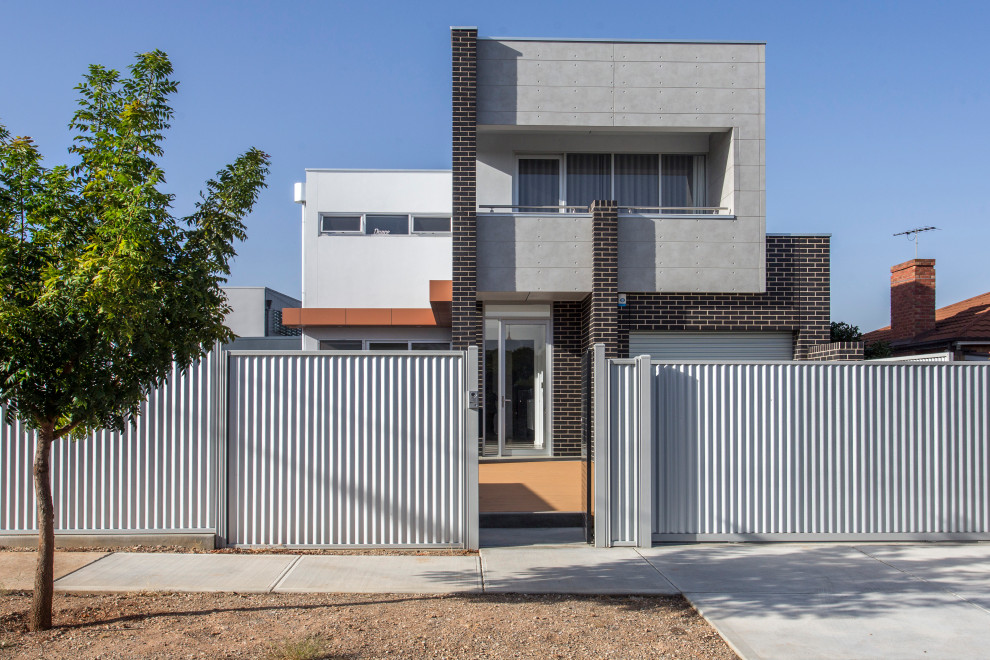 Mittelgroßes, Zweistöckiges Industrial Einfamilienhaus mit Mix-Fassade, grauer Fassadenfarbe und Flachdach in Adelaide