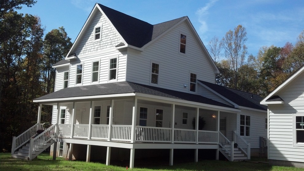 Immagine della facciata di una casa bianca country a tre piani con rivestimento con lastre in cemento