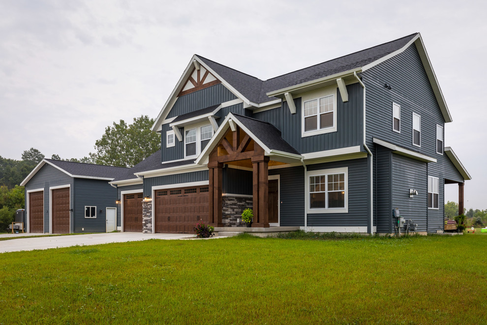 Example of a mid-sized country blue two-story vinyl exterior home design in Grand Rapids with a shingle roof