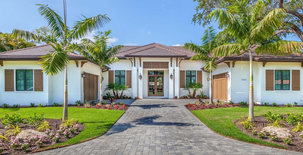 Expansive and white traditional bungalow render detached house in Tampa with a hip roof and a tiled roof.