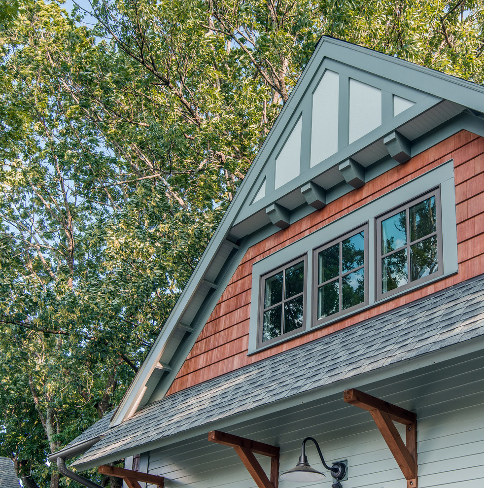 Réalisation d'une petite façade de maison verte craftsman en panneau de béton fibré à un étage avec un toit à deux pans et un toit en shingle.