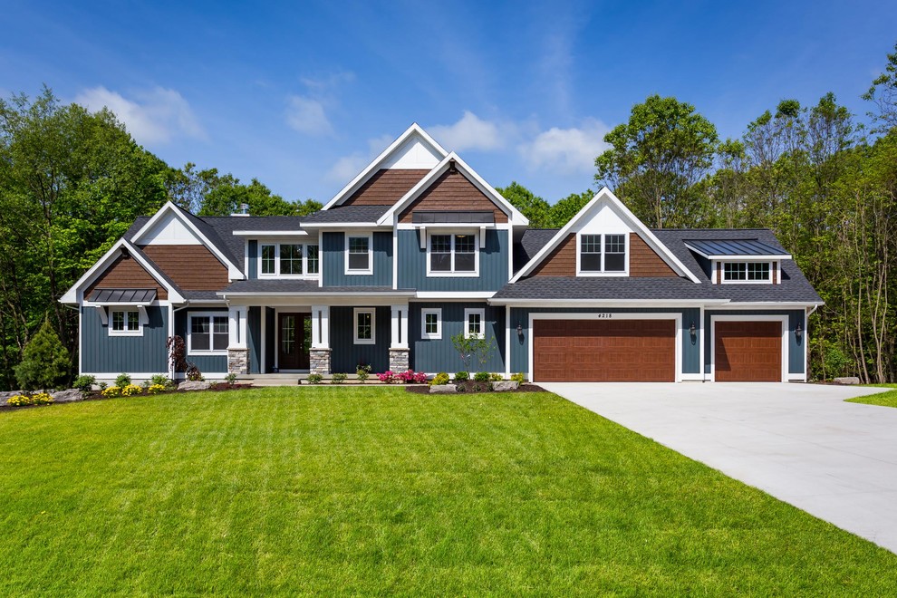 Cette photo montre une très grande façade de maison bleue nature à un étage avec un revêtement en vinyle, un toit à deux pans et un toit mixte.