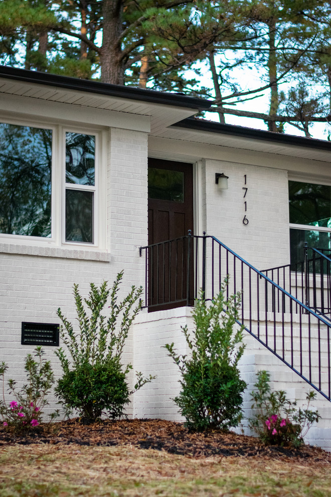 Réalisation d'une façade de maison blanche vintage en brique de taille moyenne et de plain-pied avec un toit en shingle.