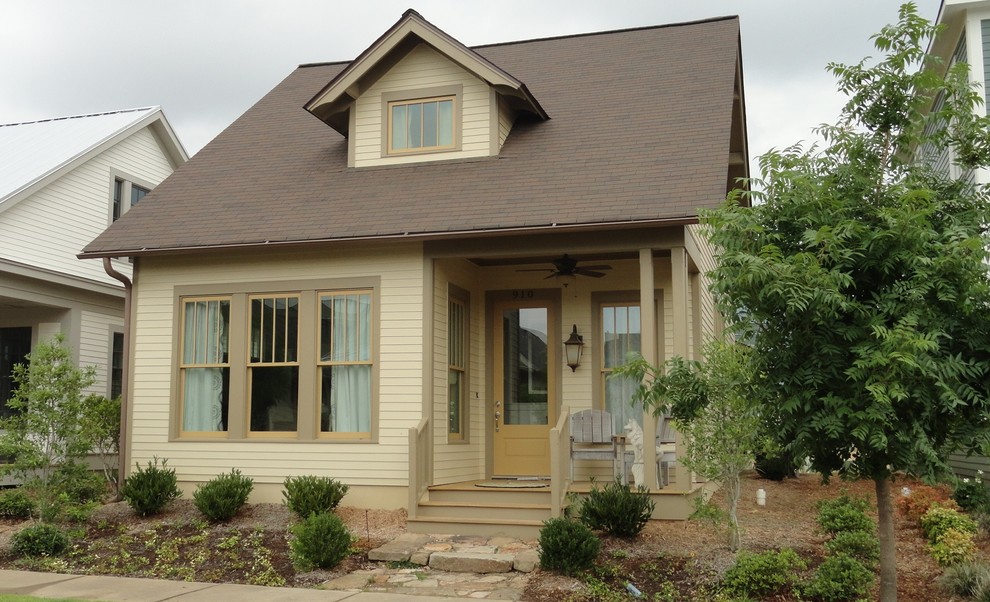 Foto della facciata di una casa beige american style con rivestimento con lastre in cemento