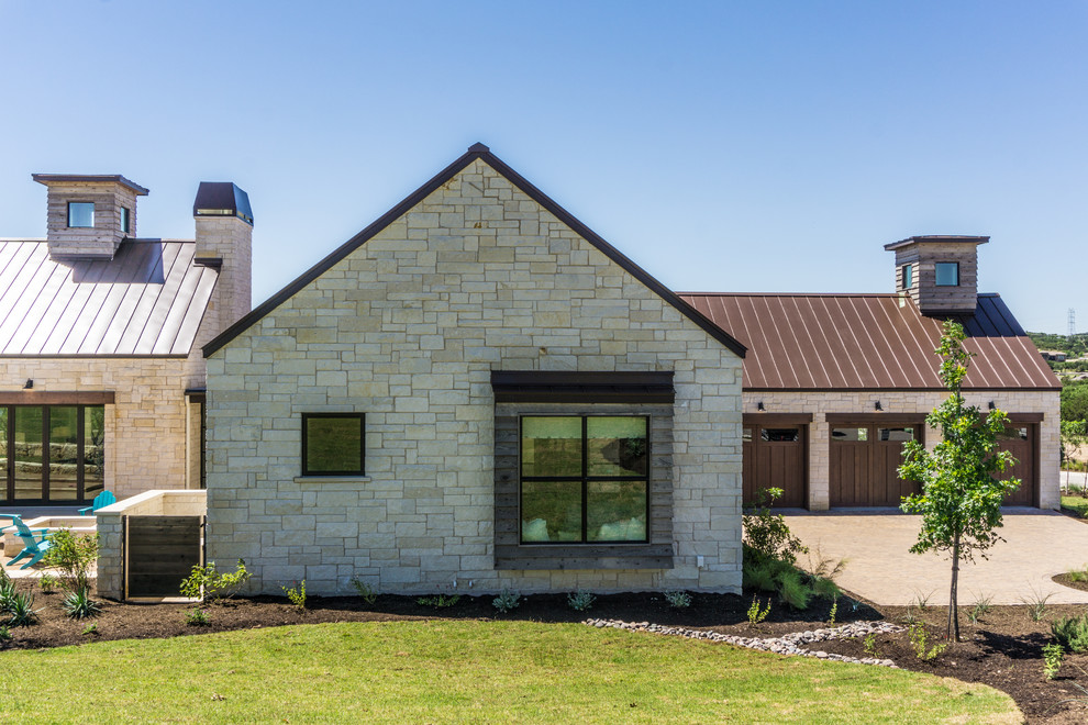 Cette image montre une grande façade de maison blanche rustique en pierre de plain-pied avec un toit en appentis et un toit en métal.