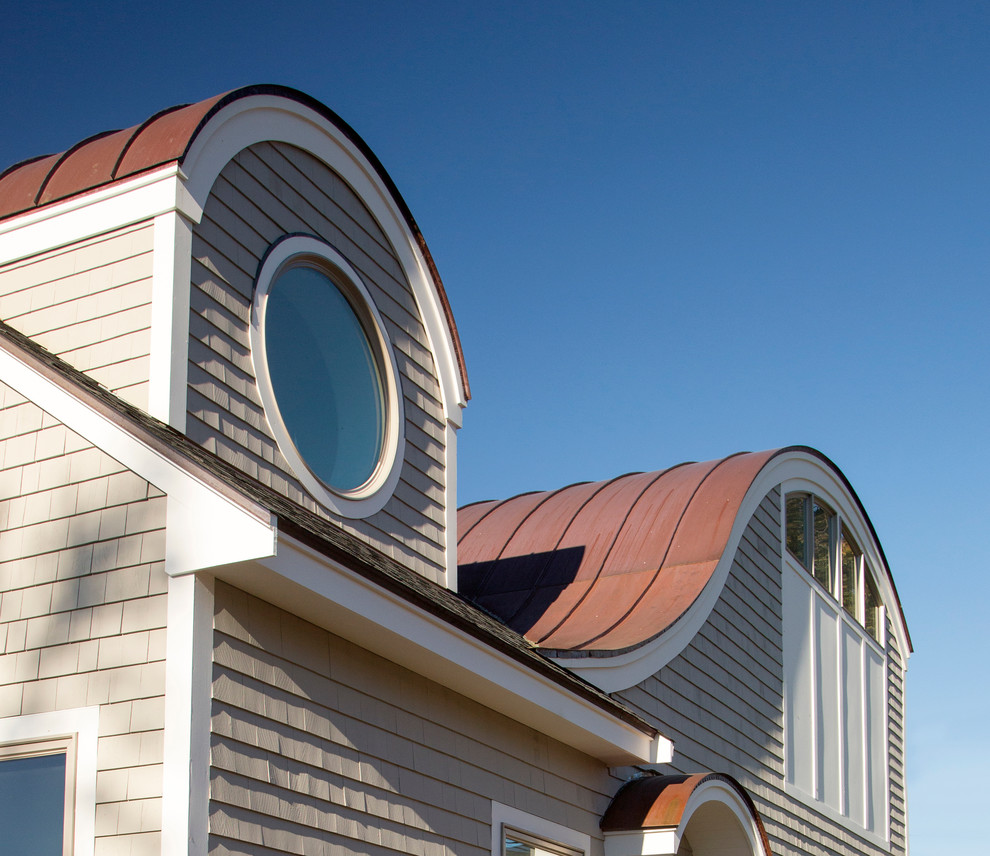 Example of a mid-sized beach style beige two-story wood gable roof design in Boston