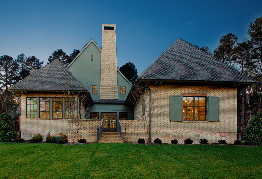 Inspiration pour une grande façade de maison beige victorienne en brique à un étage avec un toit à croupette.