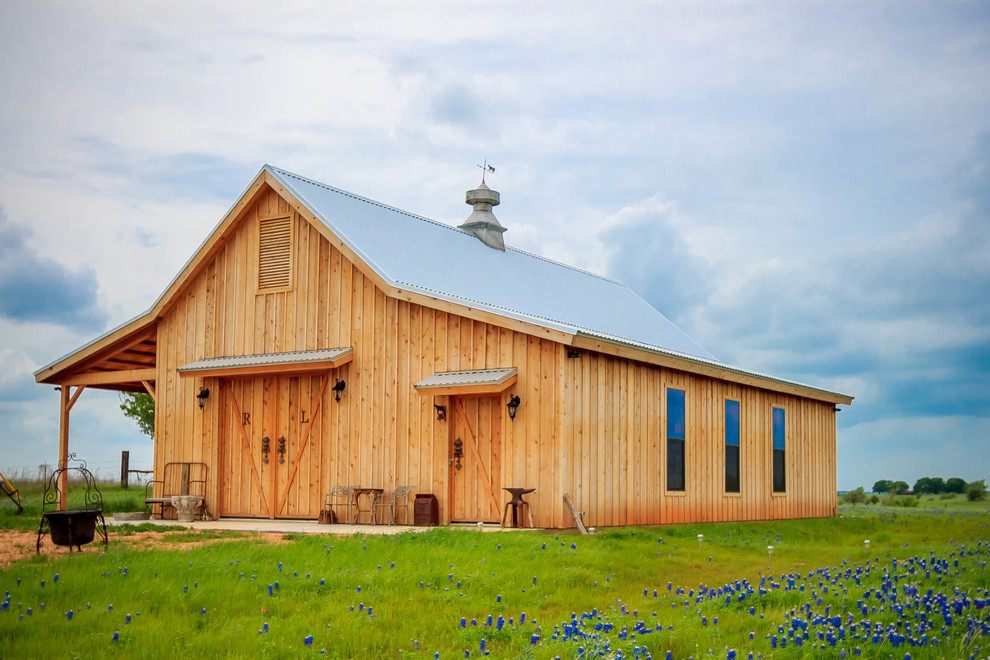 Example of a large farmhouse brown one-story wood exterior home design in Austin with a metal roof