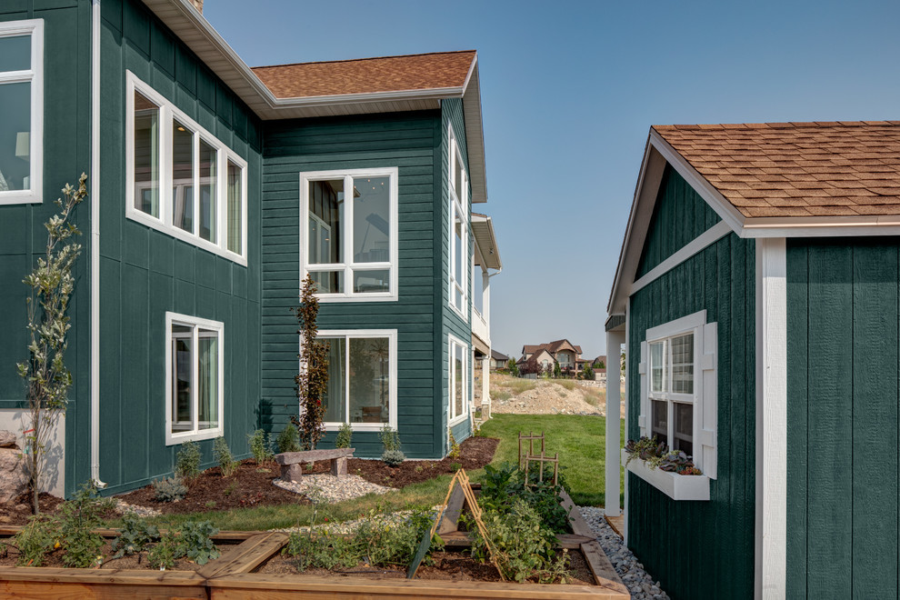 Modelo de fachada de casa verde campestre de tamaño medio de dos plantas con revestimiento de aglomerado de cemento y tejado de varios materiales