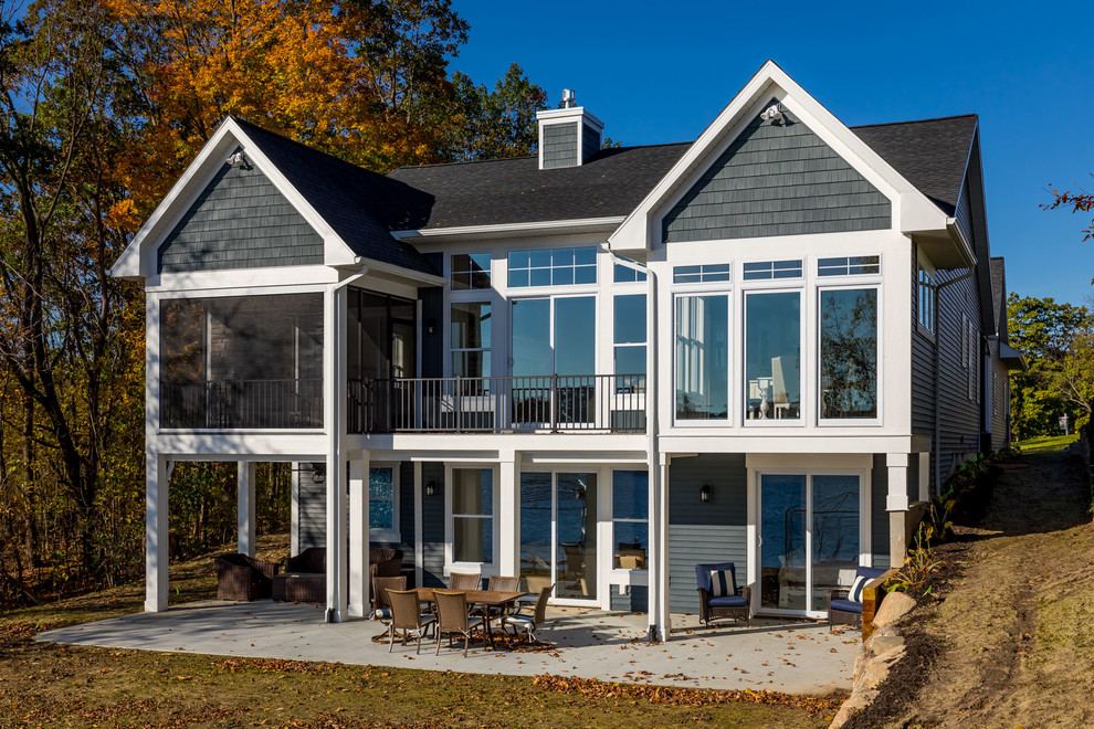 Mid-sized beach style blue two-story vinyl house exterior photo in Grand Rapids with a shingle roof