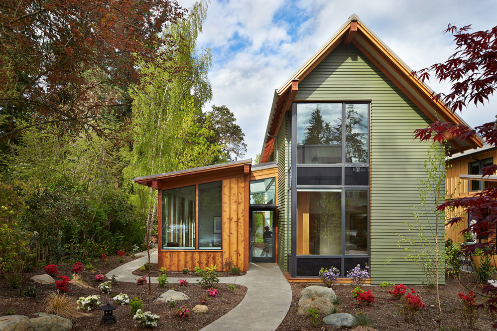 This is an example of a gey contemporary two floor house exterior in Seattle with a pitched roof.
