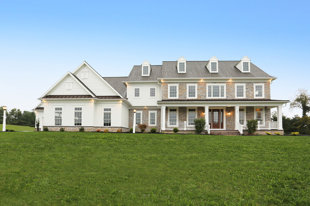 Aménagement d'une grande façade de maison blanche campagne à un étage avec un revêtement mixte, un toit à deux pans et un toit mixte.