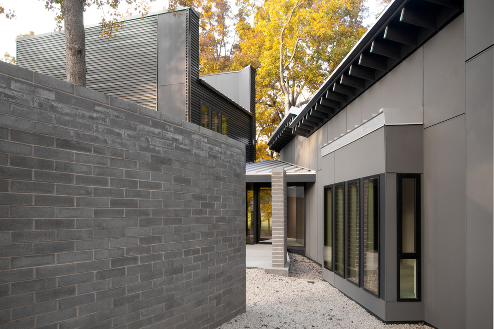 Mittelgroßes, Zweistöckiges Modernes Einfamilienhaus mit Metallfassade, grauer Fassadenfarbe, Pultdach und Blechdach in Charlotte