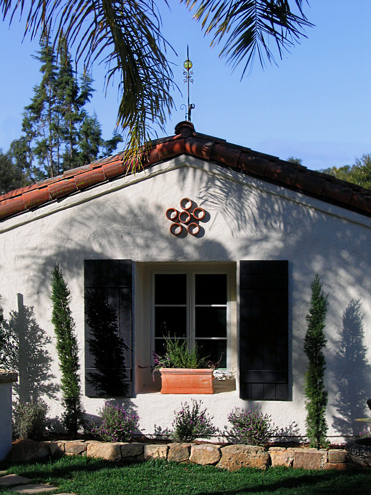 На фото: одноэтажный, белый частный загородный дом среднего размера в средиземноморском стиле с облицовкой из цементной штукатурки, полувальмовой крышей и черепичной крышей