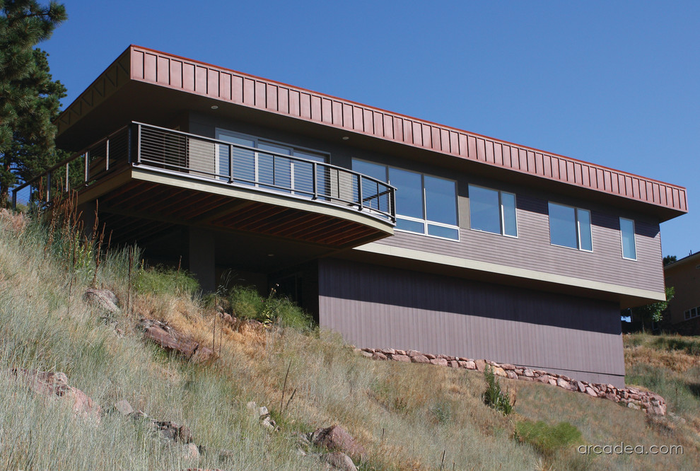 Imagen de fachada marrón minimalista de tamaño medio de dos plantas con revestimiento de estuco y tejado de un solo tendido