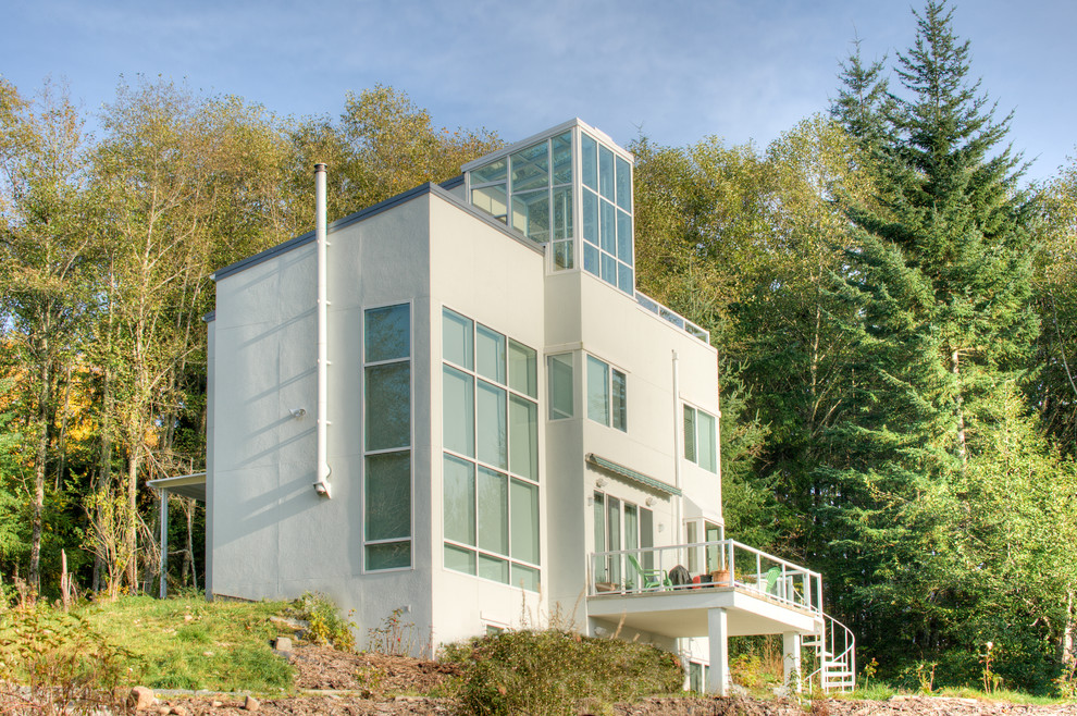 Cette image montre une façade de maison blanche minimaliste à deux étages et plus.
