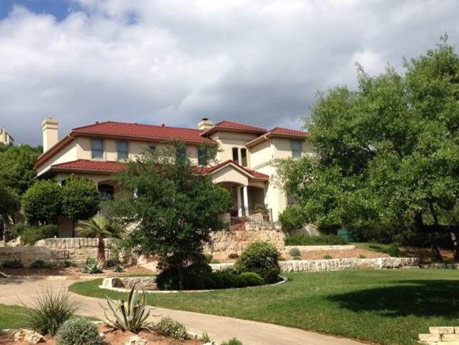 Zweistöckiges, Großes Mediterranes Einfamilienhaus mit Putzfassade, beiger Fassadenfarbe, Walmdach und Ziegeldach in Austin