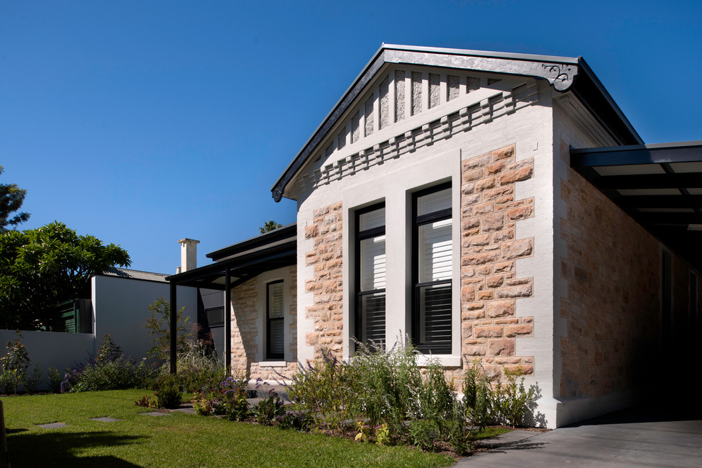 Стильный дизайн: одноэтажный, бежевый дом среднего размера в классическом стиле с облицовкой из камня и двускатной крышей - последний тренд