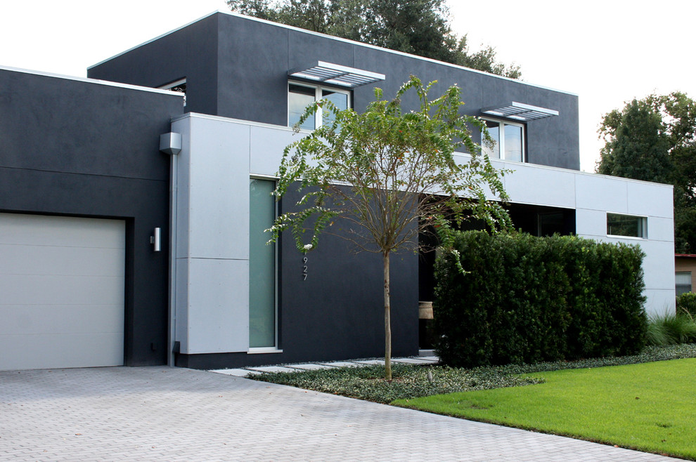 Idées déco pour une façade de maison grise moderne en stuc à un étage avec un toit plat.