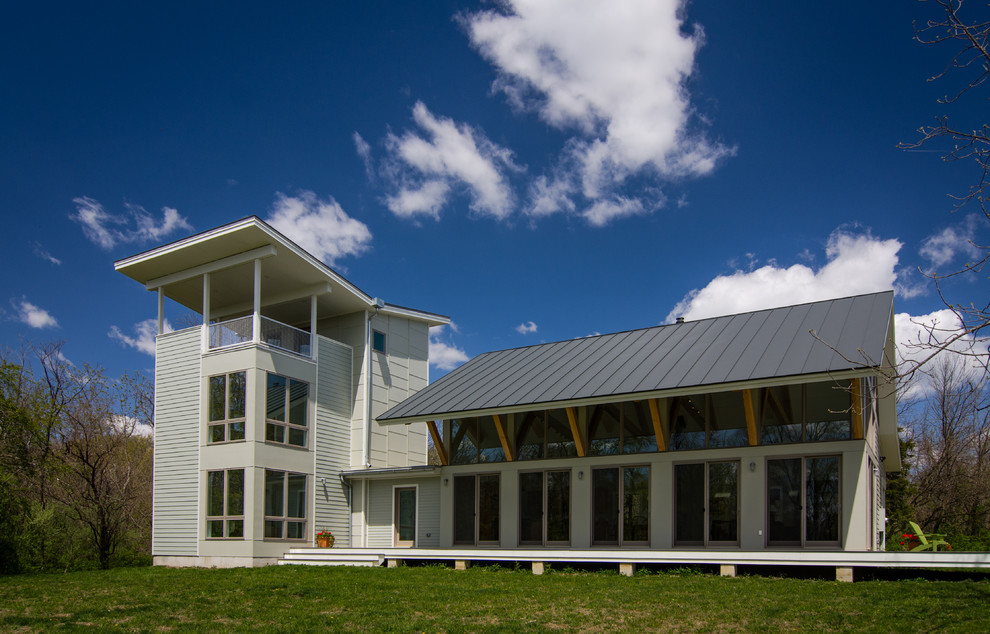 Immagine della facciata di una casa beige moderna a tre piani di medie dimensioni con rivestimento con lastre in cemento