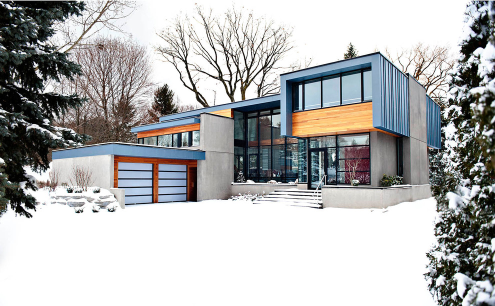 Idée de décoration pour une grande façade de maison métallique et grise design à un étage.