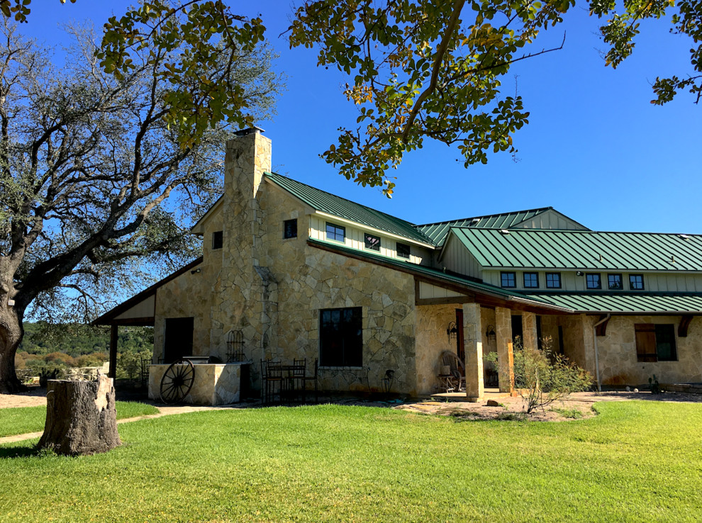 Foto de fachada de casa multicolor de estilo de casa de campo grande de dos plantas con revestimiento de piedra, tejado a dos aguas y tejado de metal