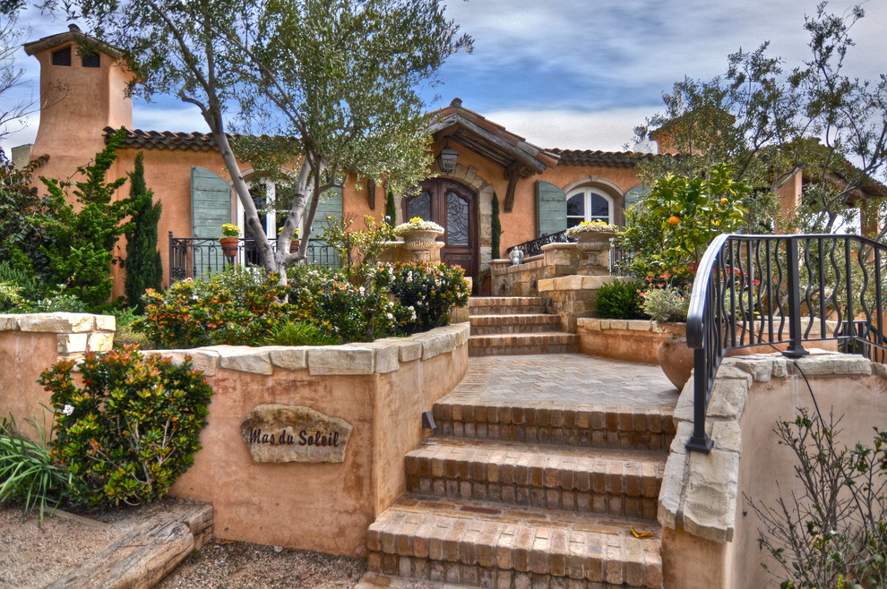 Example of a tuscan stucco exterior home design in Orange County