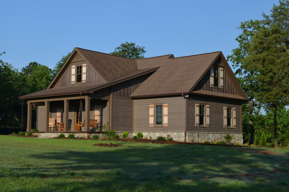 Aménagement d'une grande façade de maison marron classique en bois à un étage avec un toit à quatre pans.