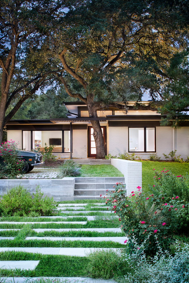 This is an example of a large and white contemporary bungalow brick house exterior in Austin.