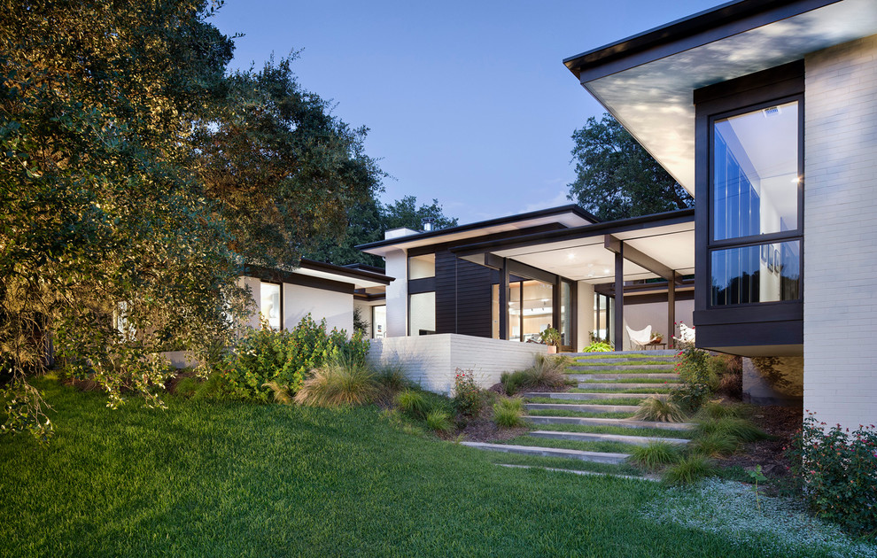 Photo of a large and white contemporary bungalow brick house exterior in Austin.