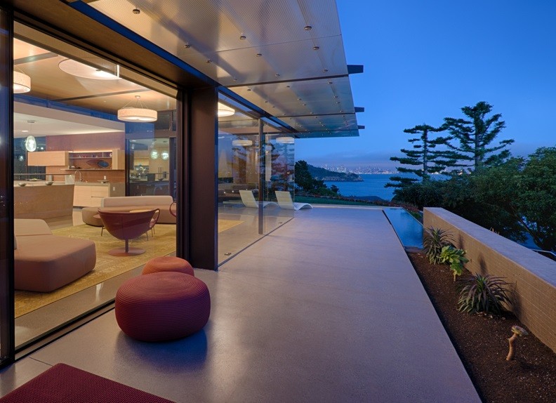 Cette photo montre une grande façade de maison multicolore moderne en verre à un étage avec un toit plat.