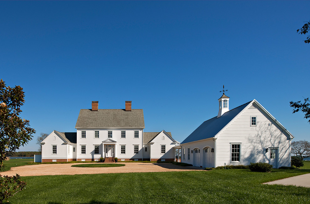 Immagine della facciata di una casa grande bianca country a due piani con rivestimento in legno