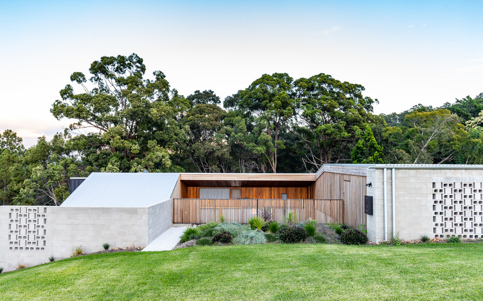 На фото: серый частный загородный дом в стиле модернизм с разными уровнями, облицовкой из бетона, плоской крышей и металлической крышей с