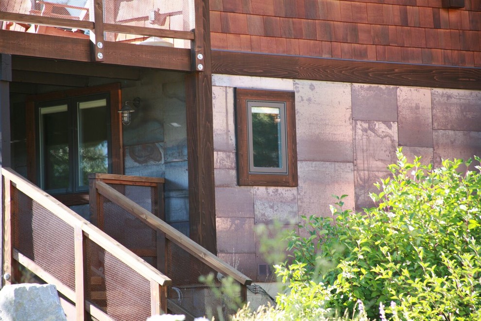Cette image montre une façade de maison marron chalet de taille moyenne et à deux étages et plus avec un revêtement mixte, un toit à deux pans et un toit en shingle.