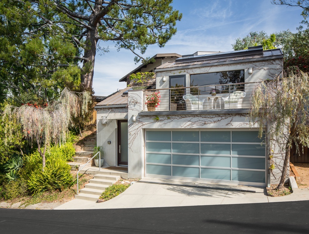 Large and gey contemporary two floor concrete detached house in Los Angeles with a pitched roof and a metal roof.