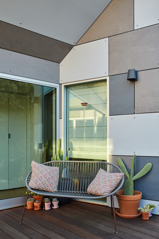 Imagen de fachada de casa gris minimalista de una planta con revestimiento de hormigón, tejado a cuatro aguas y tejado de teja de madera