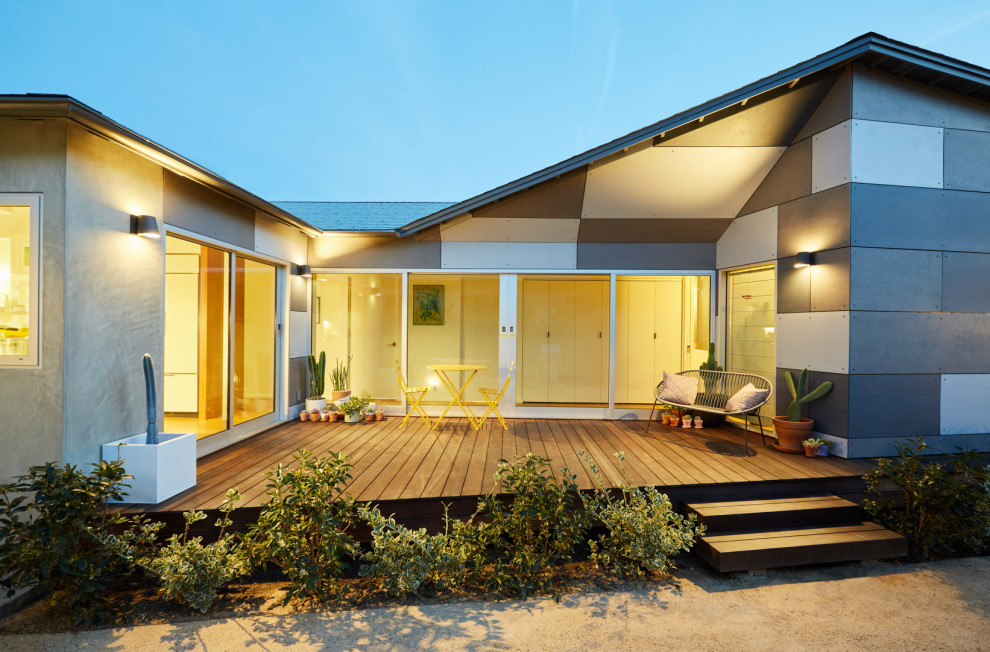 Diseño de fachada de casa gris moderna de una planta con revestimiento de hormigón, tejado a cuatro aguas y tejado de teja de madera