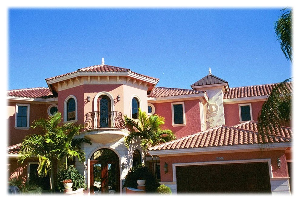 Стильный дизайн: большой, двухэтажный, красный дом в средиземноморском стиле с облицовкой из цементной штукатурки и вальмовой крышей - последний тренд